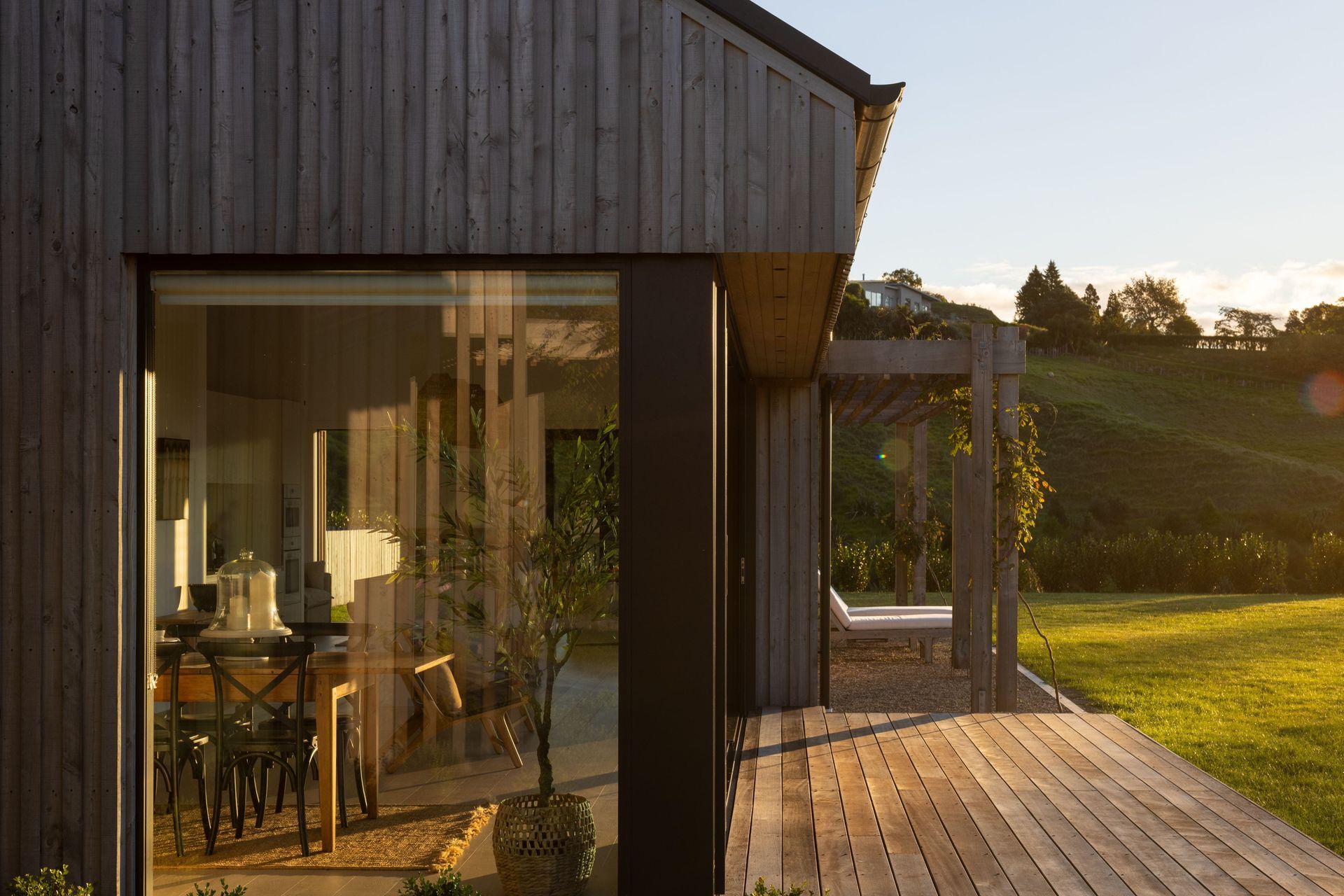 The sun sets over the living spaces pod; the extensive glazing on the northern side means the house is warm year-round.