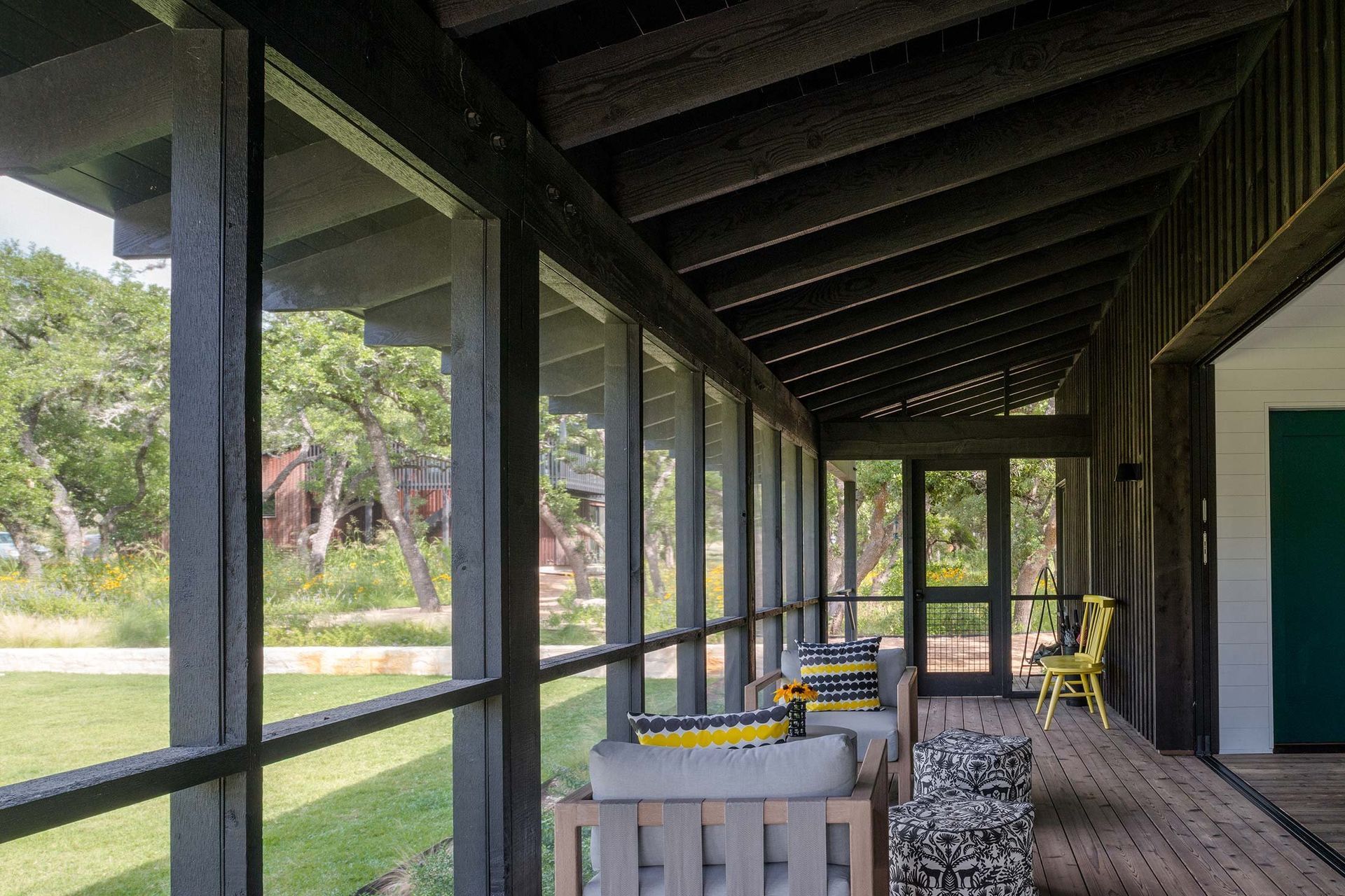 9CampFrioCuppettKilpatrickArchitectureandInteriorDesigncovered-porch-dark-wood-beams-furniture-pop-color.jpg