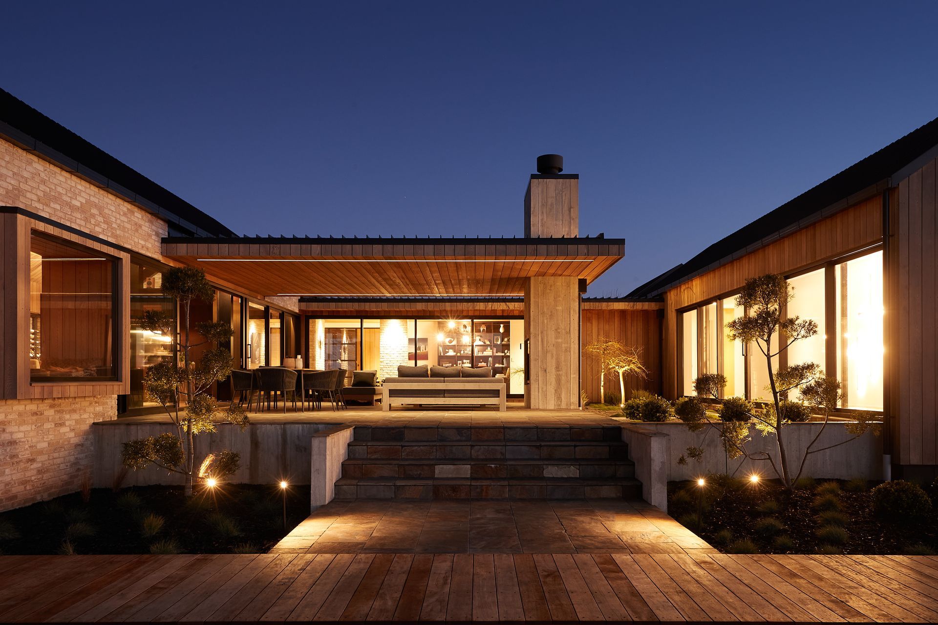 The outdoor internal courtyard with built-in outdoor fireplace features slate paving and Zen garden-like plantings.