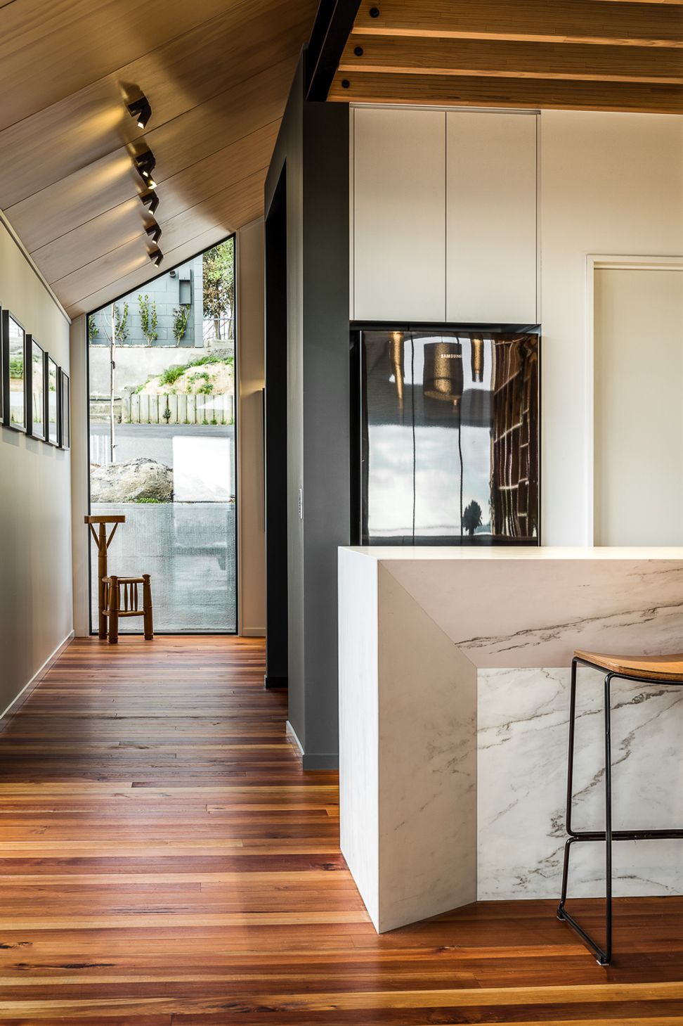 A floor-to-ceiling window on the street side of the house helps bring light into the entryway.